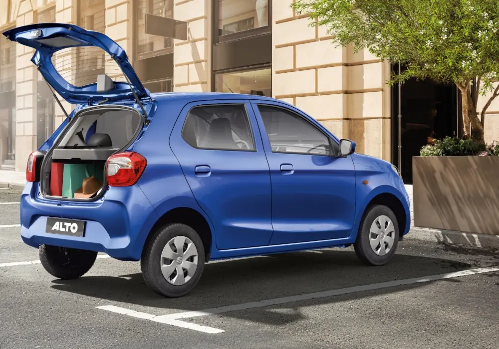Suzuki Alto azul estacionado en la calle, con el portón trasero abierto.